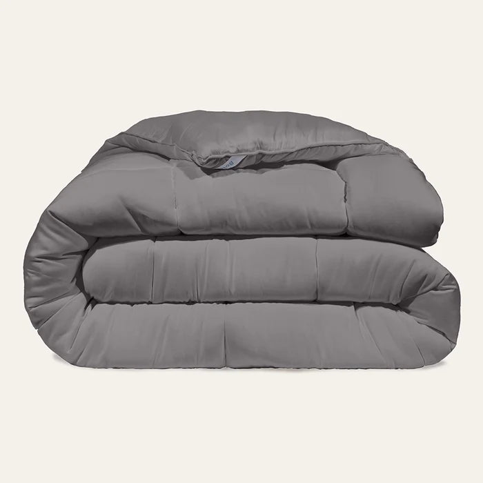 Folded gray comforter on a light beige background