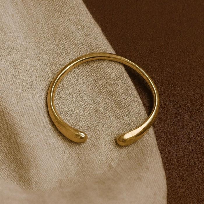 Close-up of the satin polish and protective coating on the Bantu brass bracelet, symbolizing the 'people' of Africa.