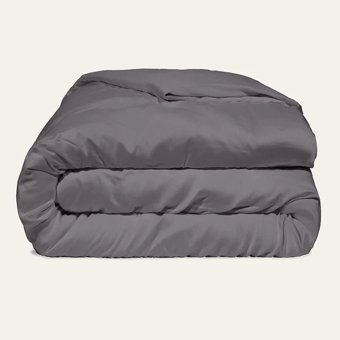 Folded gray comforter on a beige background
