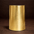 Gold cylindrical object on a dark brown background