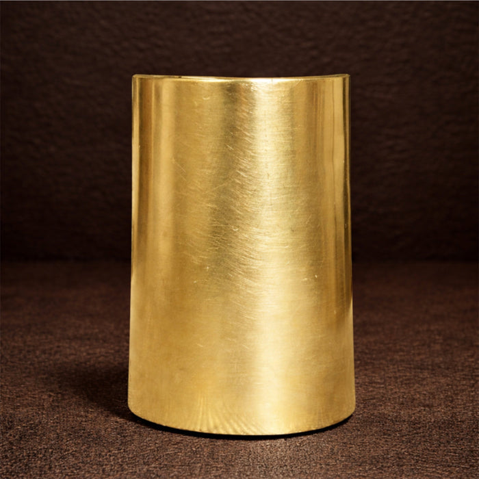 Gold cylindrical object on a dark brown background