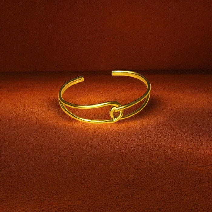 Gold bracelet on a brown fabric background