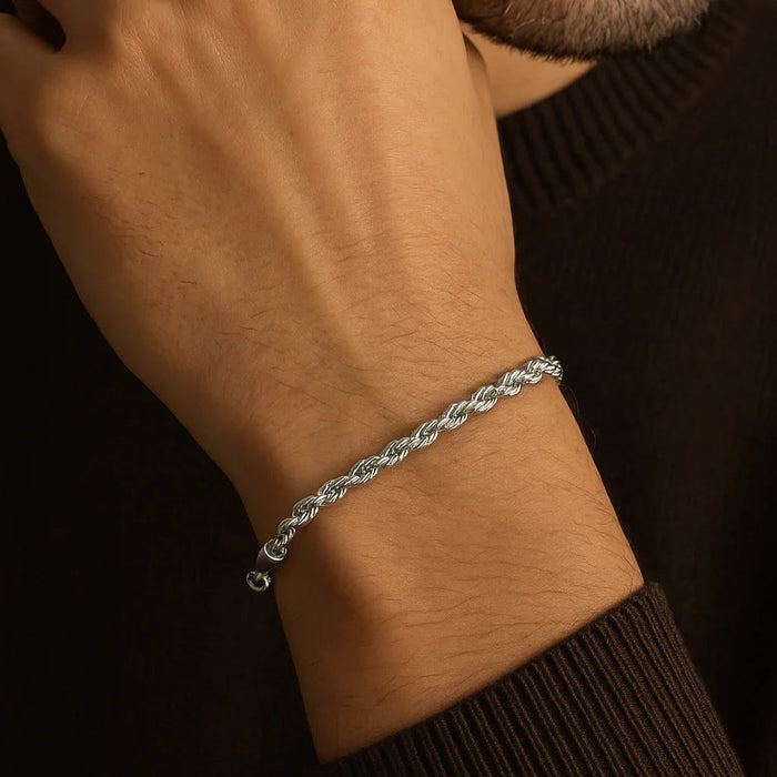 Silver bracelet on a wrist with a dark background
