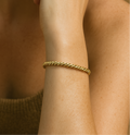 Model wearing the Keppa adjustable cuff, showing the texture and movement of the twisted brass on the wrist.