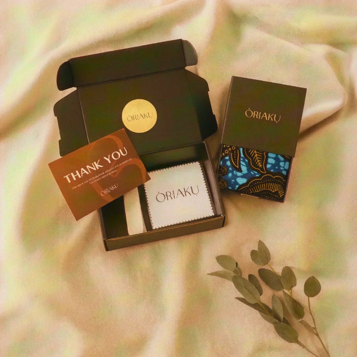 Oriaku product packaging with a 'Thank You' card on a soft fabric background