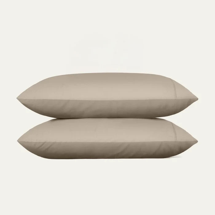 Two beige pillows stacked on a white background