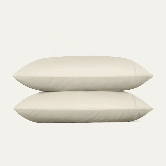 Two beige pillows on a white background