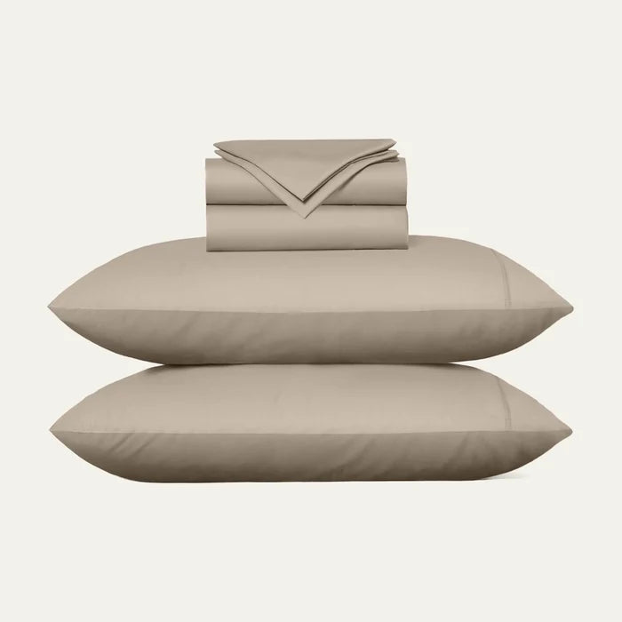 Beige bed sheets and pillows on a white background