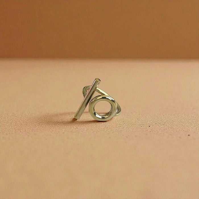 Silver ring with a unique design on a beige background