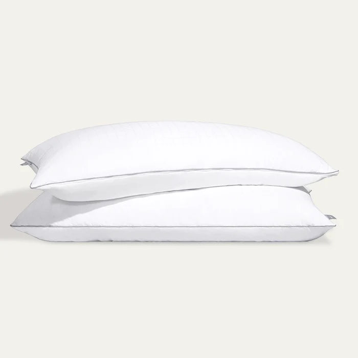 Two white pillows stacked on a light beige background
