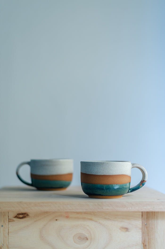 Håndlaget rund kopp i stentøy med en organisk form som ligger godt i hånden, perfekt til kaffe eller te.