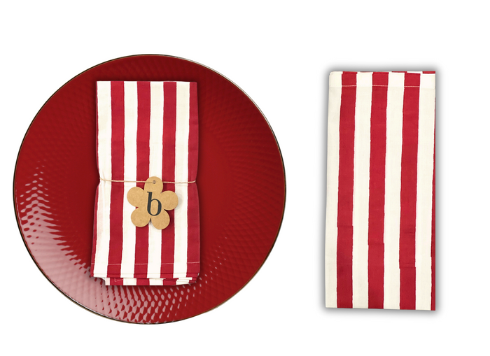 Red plate with a striped napkin and wooden holder on a white background