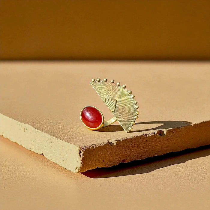 The Tano statement ring by Oriaku Studio, featuring a deep red natural stone set in handcrafted brass.