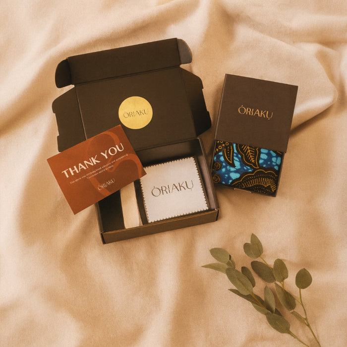 Oriaku product packaging with a 'Thank You' card on a beige fabric background